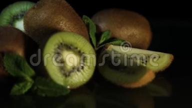 美味美丽的水果猕猴桃和薄荷躺在黑桌上。 从桌子上反射猕猴桃。 高清。 特写